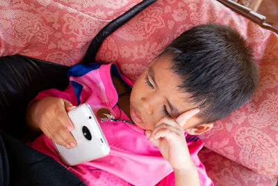 High angle view portrait of girl lying on bed