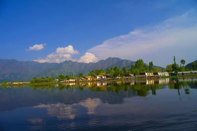 Scenic view of lake by buildings against sky