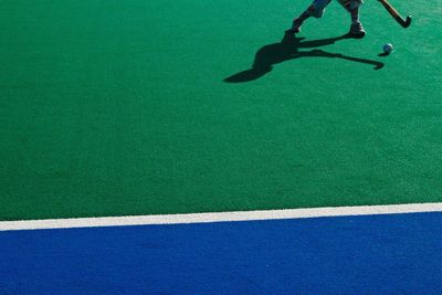 Low section of man playing hockey on field