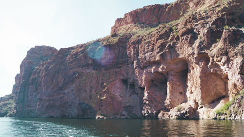 Rock formations by sea against sky