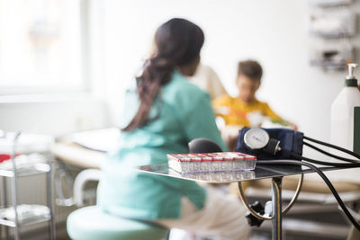 Rear view of female pediatrician with boy in clinic