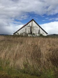 Abandoned barn on field against sky