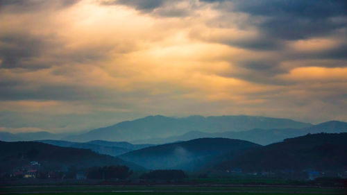 Scenic view of mountains against cloudy sky