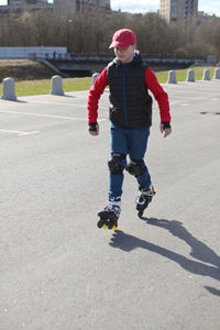 Full length of boy skateboarding on skateboard in winter