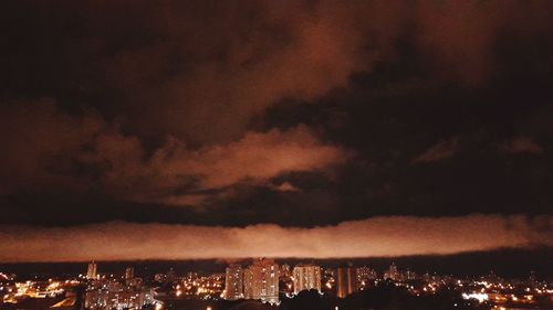Illuminated cityscape against sky at night