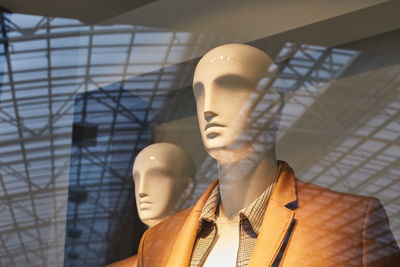 Close-up of mannequins seen through store window