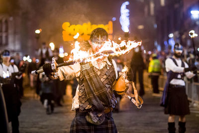 Crowd on illuminated street at night in city