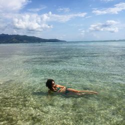 Man swimming in sea against sky