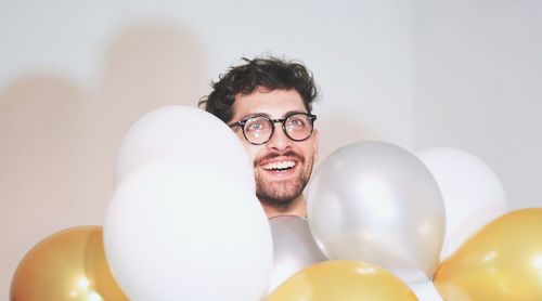 Portrait of smiling young man with balloons