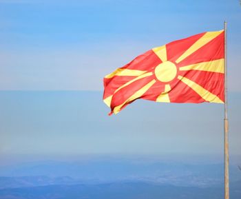 Low angle view of flag against clear blue sky
