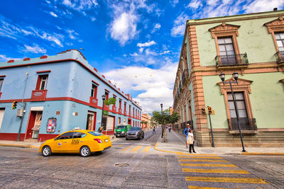 Vehicles on road against buildings in city