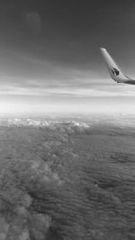 Airplane flying over landscape against sky