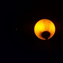 Low angle view of illuminated lamp post at night