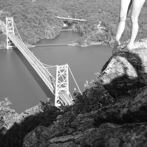 Low section of person by suspension bridge over water