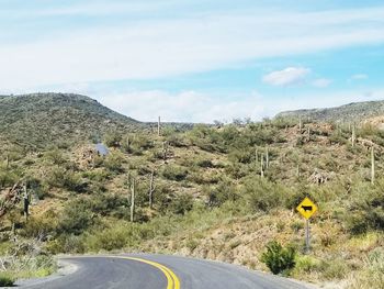 Road passing through landscape against sky