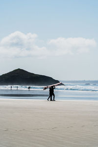 People on beach against sky