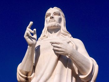 Low angle view of statue against blue sky