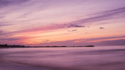 Scenic view of sea against romantic sky at sunset