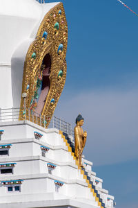 Low angle view of statue against building against sky