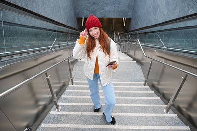 Portrait of young woman walking on staircase