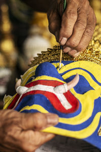 Cropped hand of woman holding multi colored flags