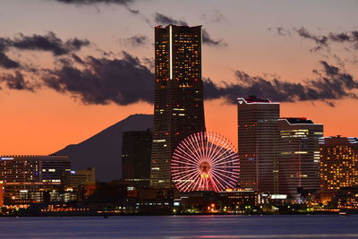 River with illuminated buildings in distance at night