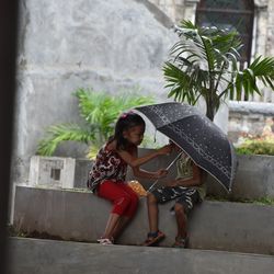 Full length of woman holding umbrella during rainy season