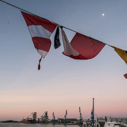 Low angle view of flags against sky during sunset