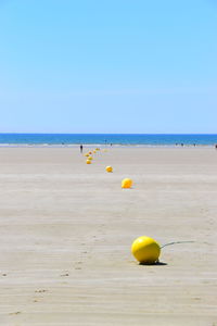 Yellow floating on sea against clear sky