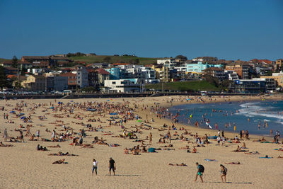 People on beach against clear sky