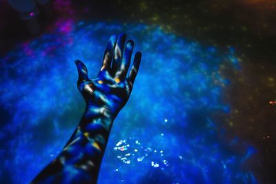 High angle view of projection light reflecting on hand