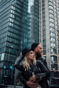 Young couple standing against building in city