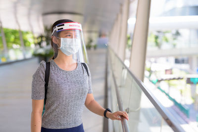 Portrait of girl standing against glass