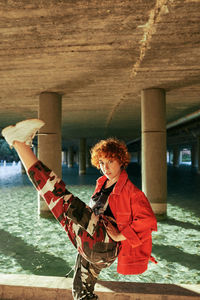 Mixed heritage asian-spanish young female posing with red jacket