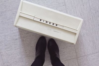 Close-up of person standing on tiled floor