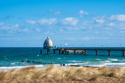 View of pier on sea against cloudy sky