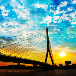 Low angle view of suspension bridge against sky during sunset