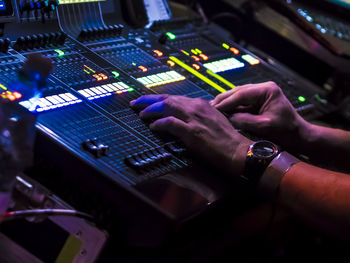 Cropped hands of male dj using control panel during music concert