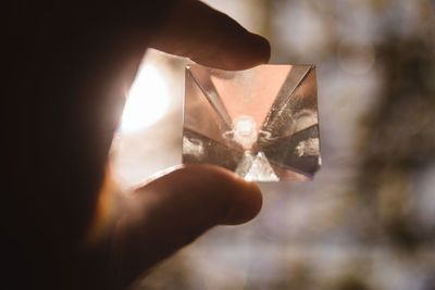 Close-up of hand holding crystal gemstone