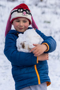 Portrait of boy wearing hat standing in snow