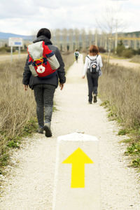 Rear view of people walking on road