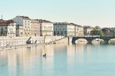 View of birds in river with buildings in background