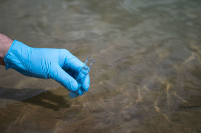 High angle view of hand holding umbrella over water