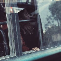 Close-up of person looking through window