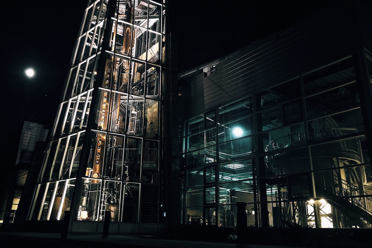 night, illuminated, built structure, architecture, low angle view, building exterior, lighting equipment, metal, sky, construction site, building, railing, street light, industry, factory, outdoors, city, dark, light - natural phenomenon, no people