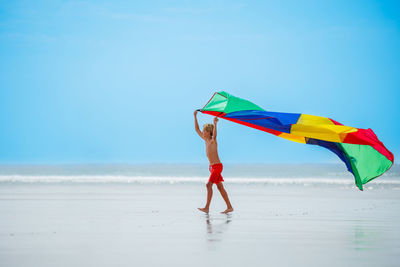 Rear view of woman holding umbrella