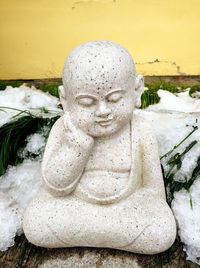 Close-up of buddha statue against water