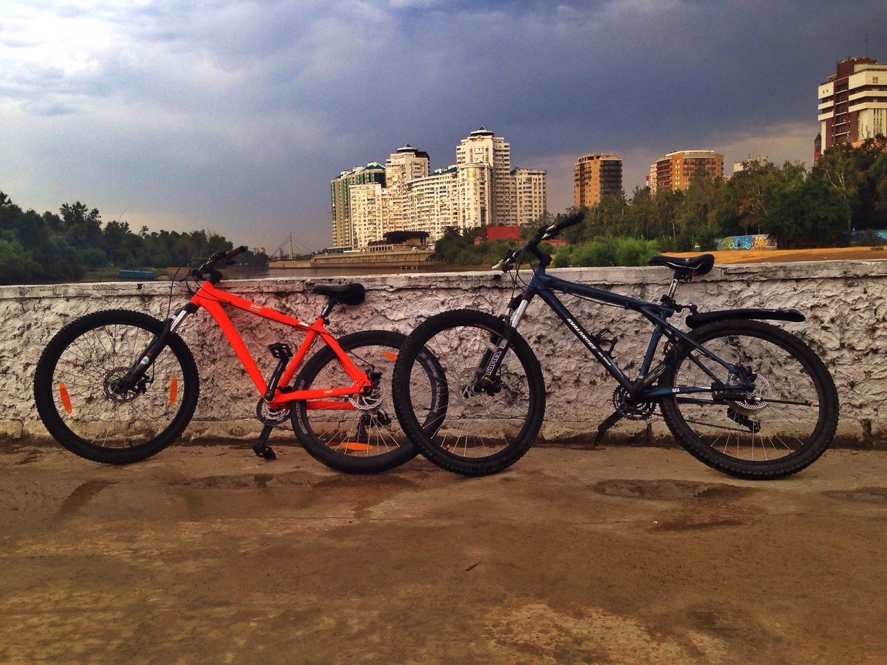 bicycle, transportation, land vehicle, mode of transport, architecture, building exterior, built structure, stationary, parked, parking, city, sky, street, cloud - sky, day, outdoors, road, no people, parking lot, cycle