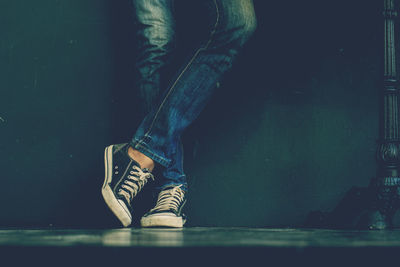 Low section of person wearing jeans while standing on floor