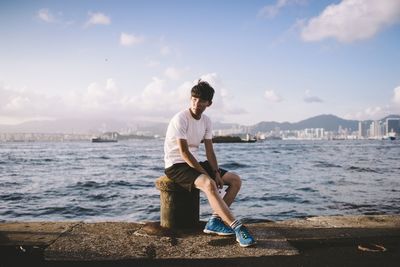 Full length of woman standing by sea against sky